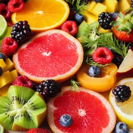 Arrangement de fruits contenant des kiwis, des pamplemousses, des oranges, des bleuets, des framboises, des fraises et des baies